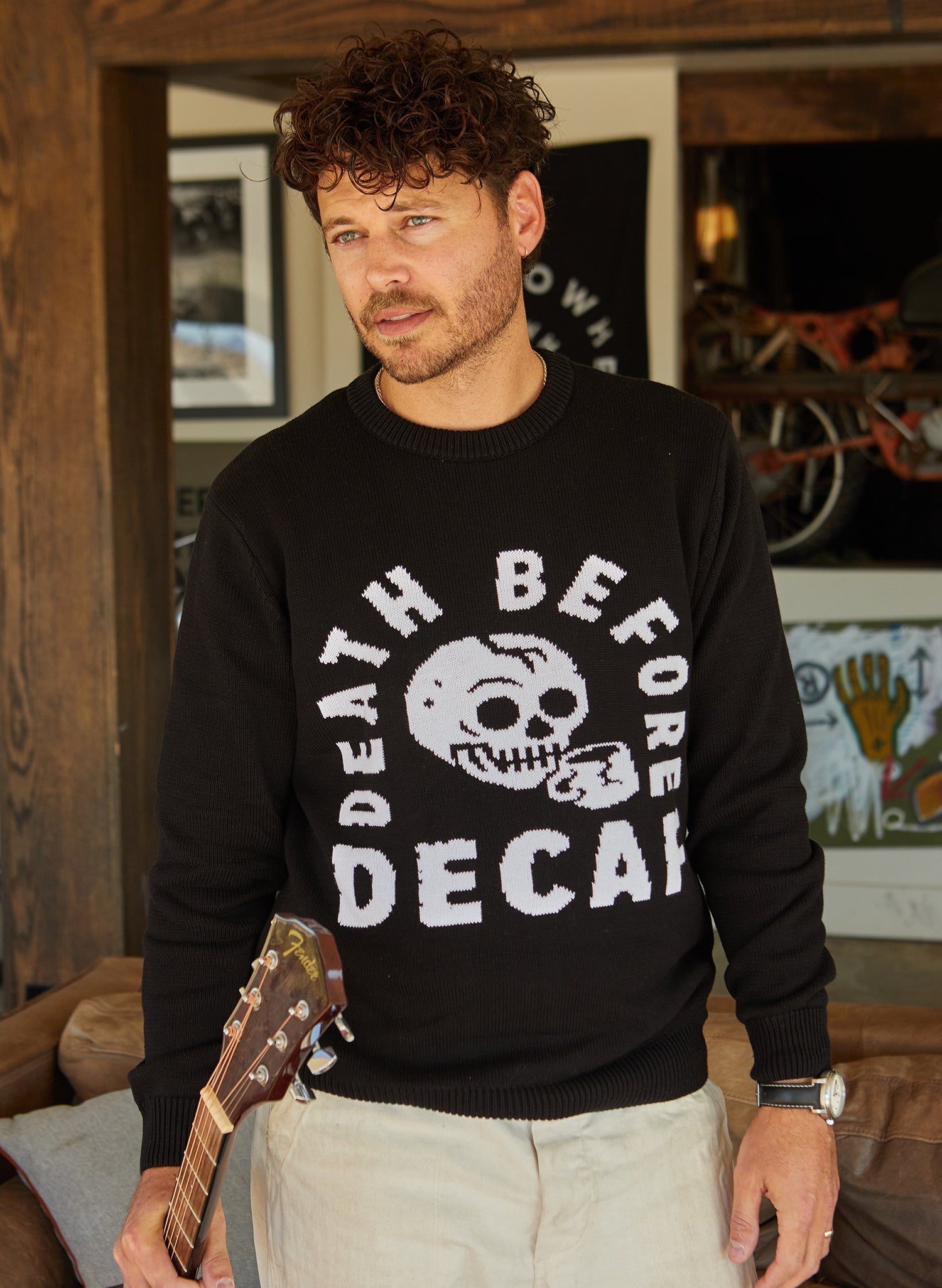Man wearing a black sweater with &