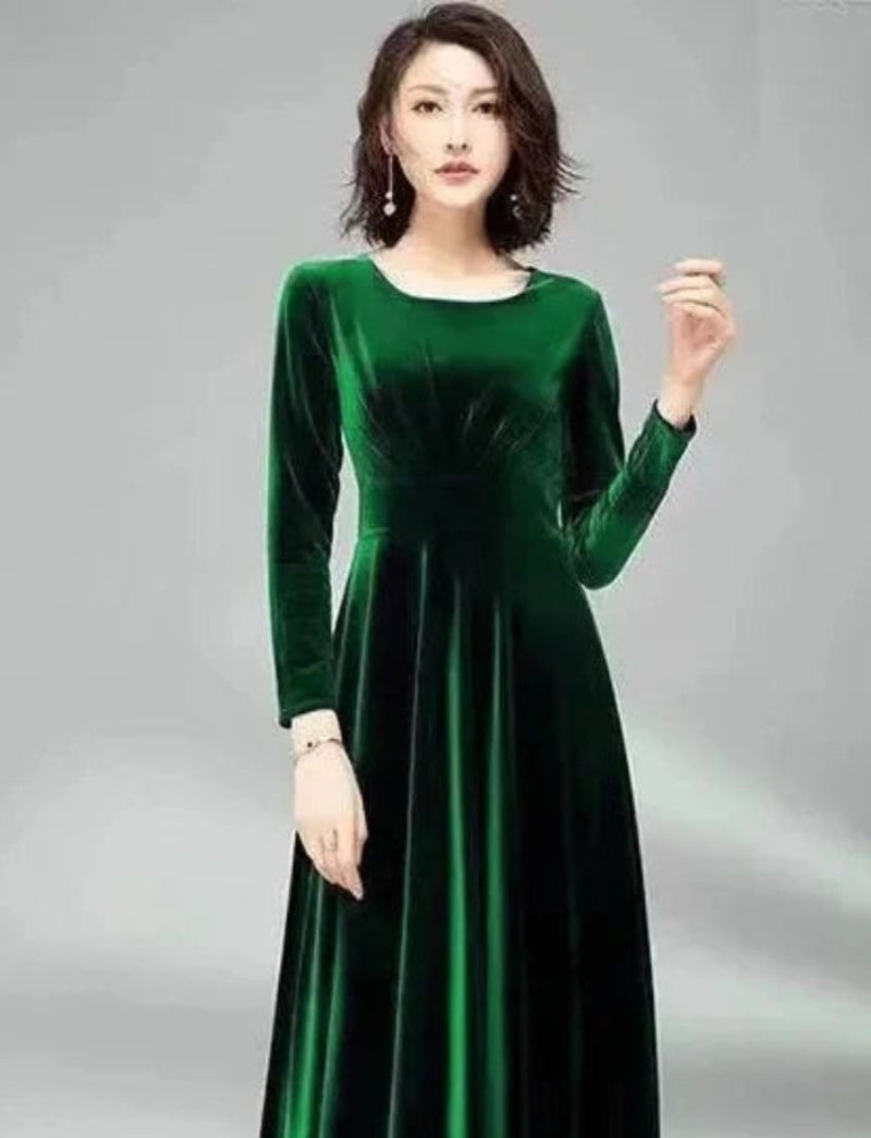 Woman wearing a green velvet dress against a gray background