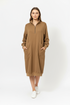 A woman wearing a brown sweater dress with pockets.