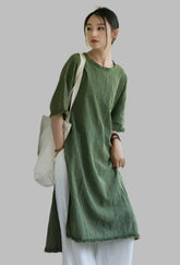 Woman in a green dress standing in an abandoned building