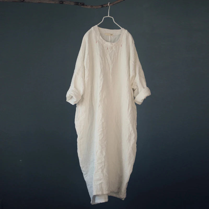 Beige long dress hanging on a dark gray background