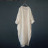 Beige long dress hanging on a dark gray background