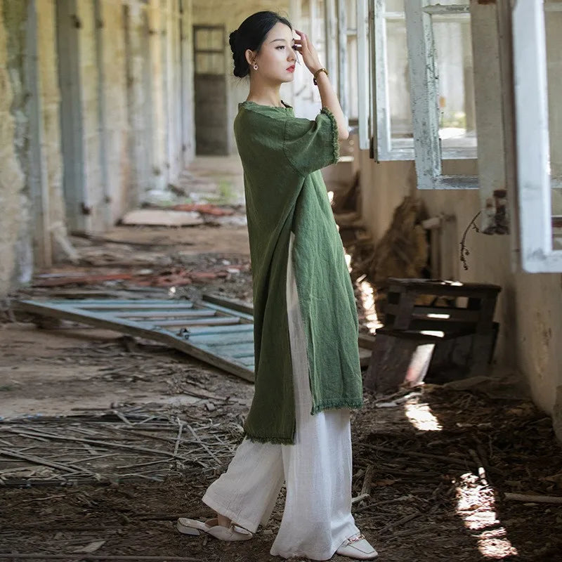 Woman in a green and white traditional outfit standing in an abandoned building.