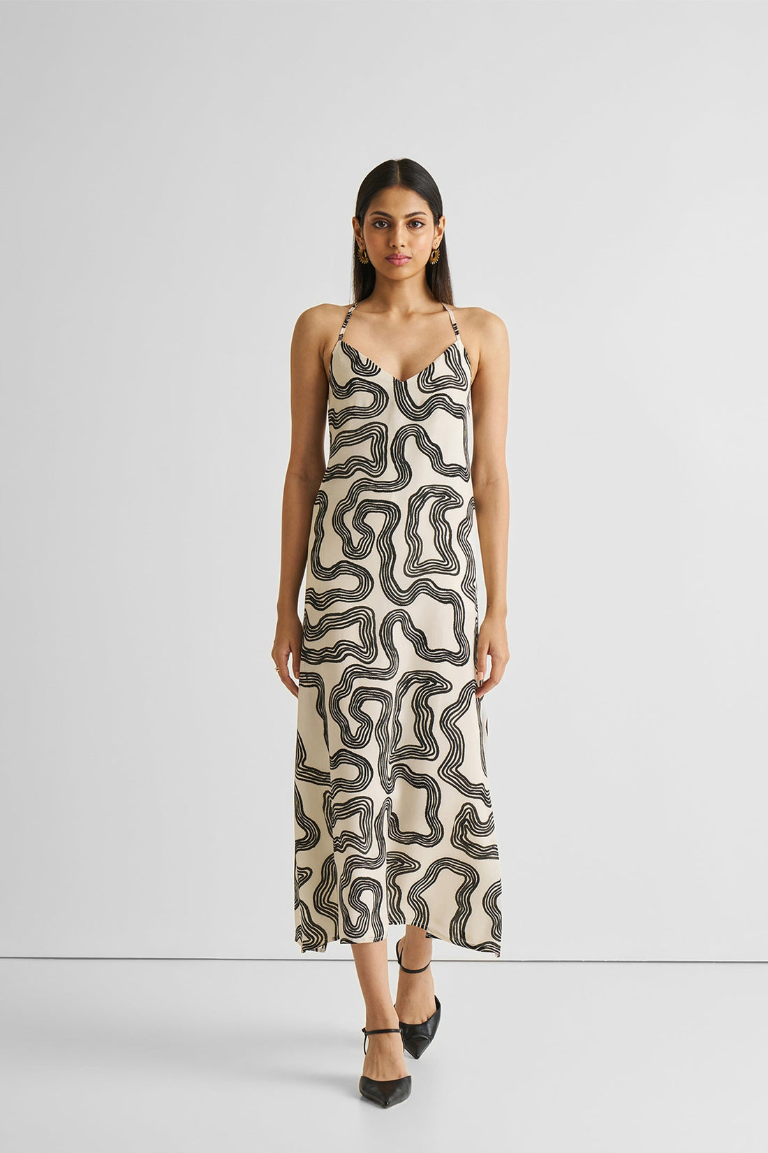 Woman wearing a patterned slip dress on a white background