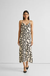 Woman wearing a patterned slip dress on a white background