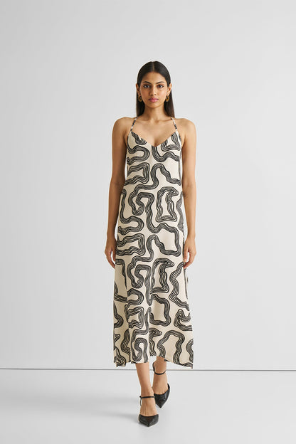 Woman wearing a patterned slip dress on a white background