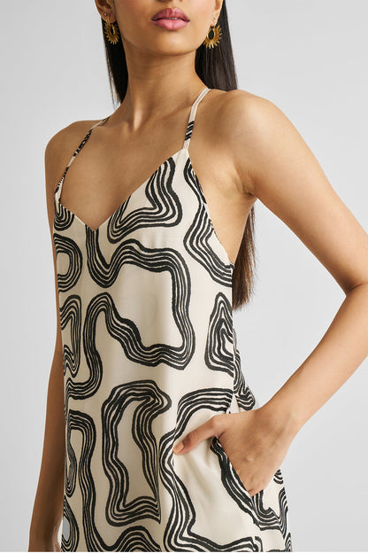 Woman wearing a black and white patterned dress against a plain background