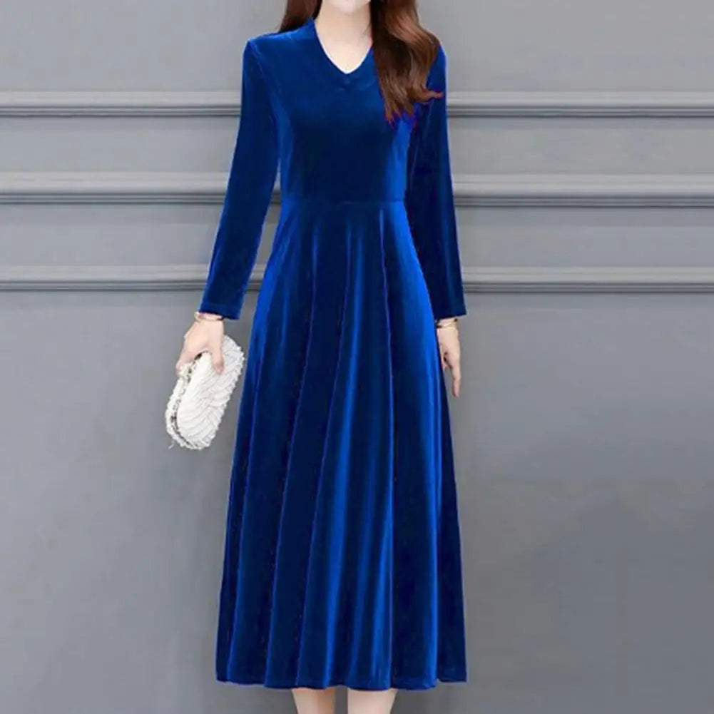 Woman wearing a blue velvet dress against a gray background