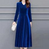 Woman wearing a blue velvet dress against a gray background