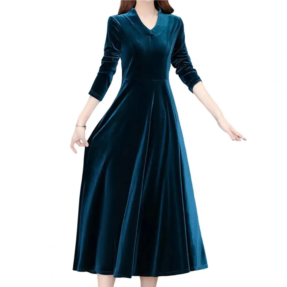 Teal velvet dress worn by a model on a white background