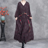 Long dark brown dress with floral patterns on a gray background