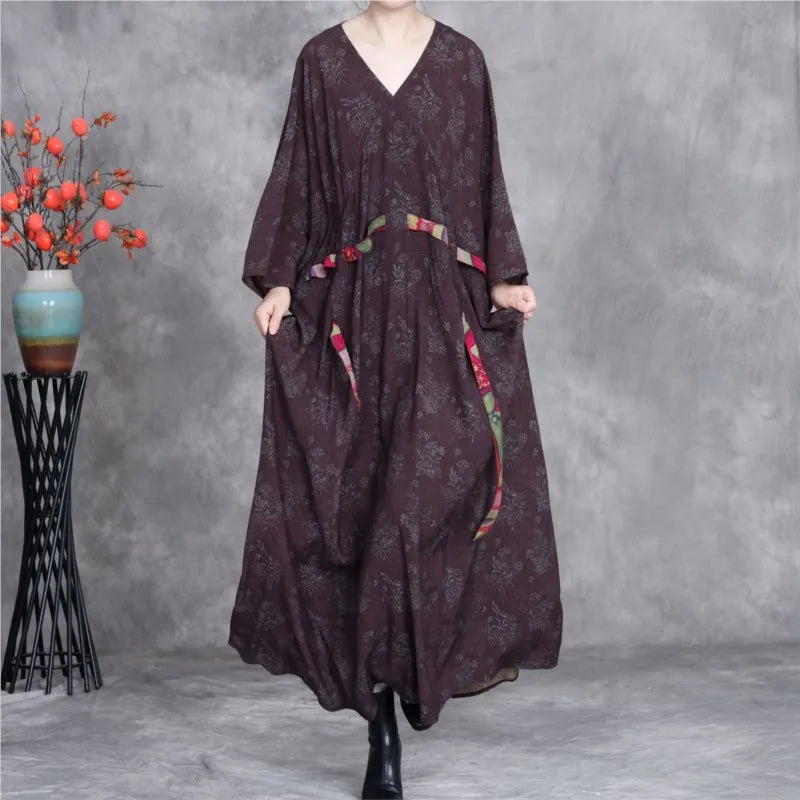 Long dark brown dress with floral patterns on a gray background