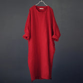 Red dress on a hanger against a dark gray background