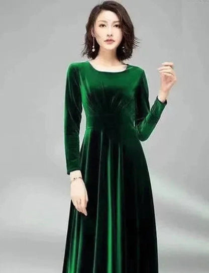 Woman wearing a green velvet dress against a gray background